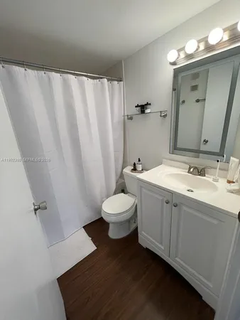 a bathroom with a double vanity sink toilet and a mirror