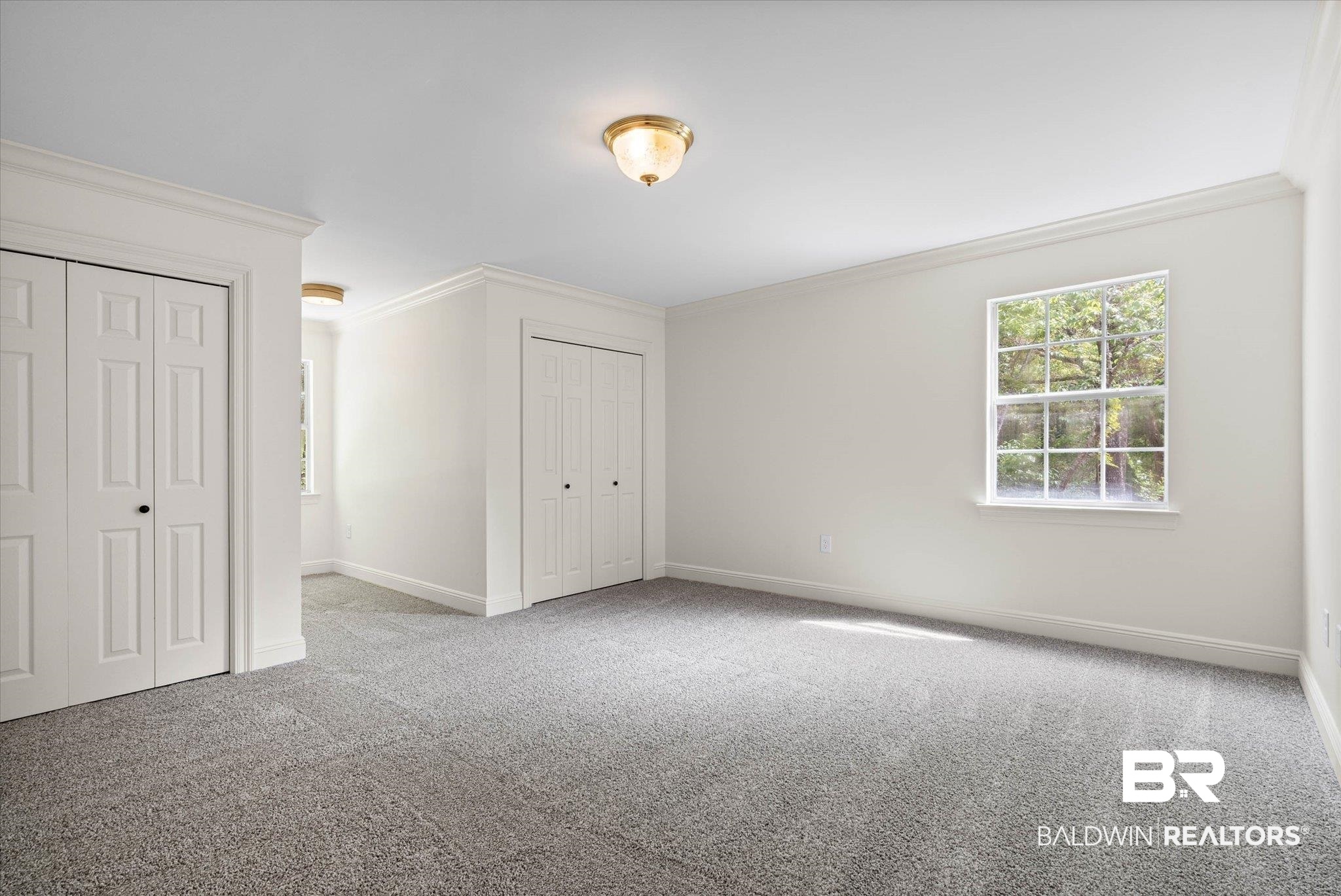 3451 Lacoste Road Mobile, AL 36618 - Photo 25 of 36 Unfurnished bedroom featuring multiple closets, carpet, and ornamental molding