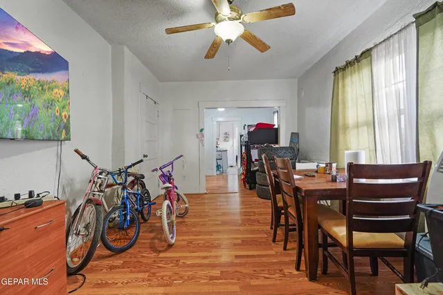 a view of a dining room with furniture one side kitchen view and wooden floor