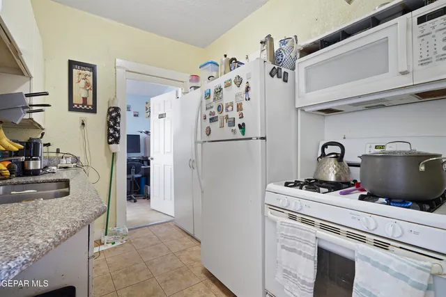 a kitchen with stainless steel appliances granite countertop a refrigerator and a stove
