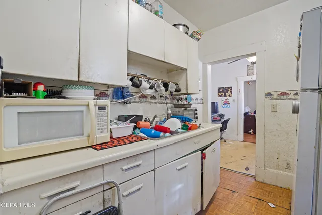 a kitchen with stainless steel appliances a white cabinets and wooden floor