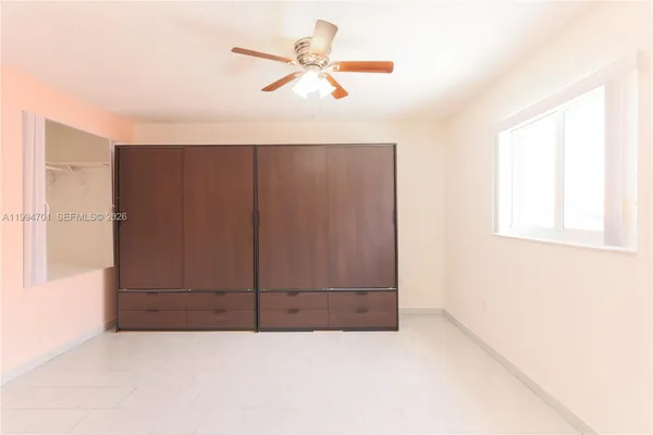 an empty room with closet and windows