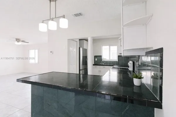 a kitchen with stainless steel appliances granite countertop a sink a counter space and cabinets