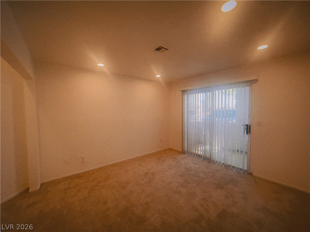 6250 West Flamingo Road, Unit 60 Las Vegas, NV 89103 - Photo 8 of 23 This living area features a glass sliding door, recessed lighting, and soft carpeting.