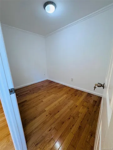 a view of a room with wooden floor and white walls