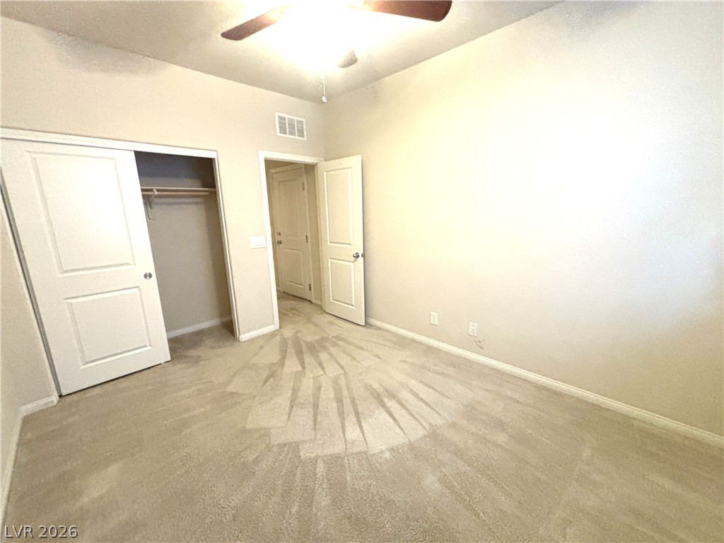 121 Elm Reed Avenue Las Vegas, NV 89113 - Photo 14 of 30 A well-lit bedroom offering plush carpet and a convenient closet for optimal living.