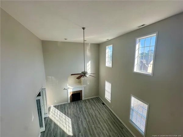 a view of a room with wooden floor wooden cabinet and windows