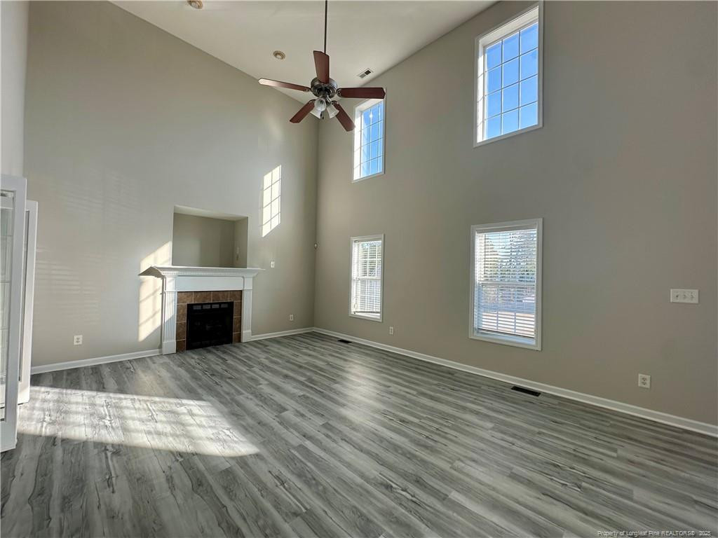 11 Lattimore Road Cameron, NC 28326 - Photo 3 of 18 an empty room with wooden floor fireplace and windows
