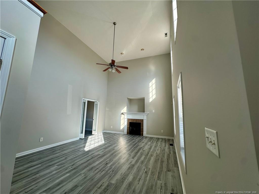 11 Lattimore Road Cameron, NC 28326 - Photo 4 of 18 an empty room with wooden floor a ceiling fan and windows