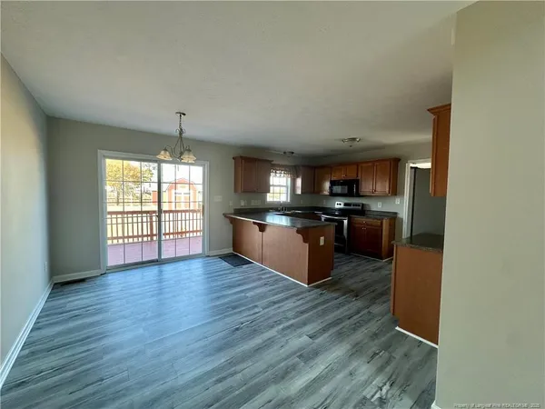 a large kitchen with wooden floor and stainless steel appliances