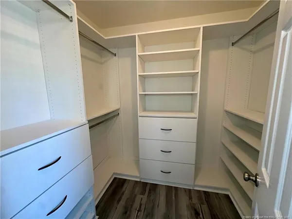 a view of walk in closet with empty racks