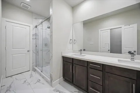 a bathroom with a double vanity sink mirror double and shower