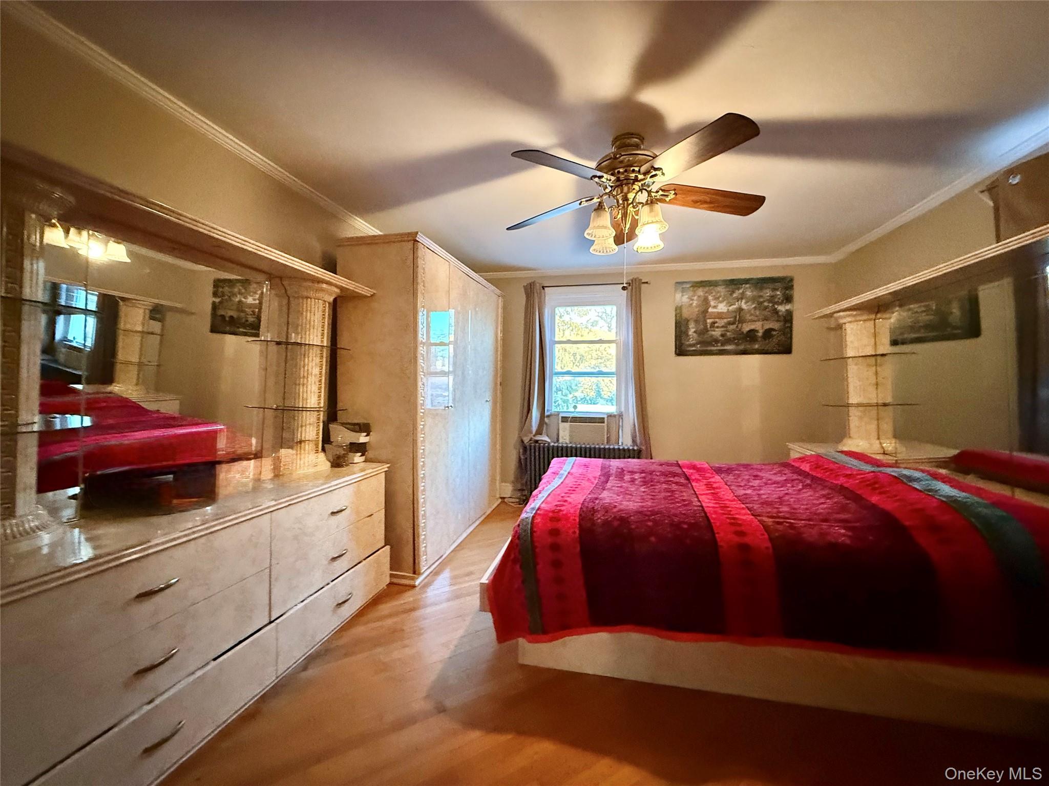 54-05 68th Street Queens, NY 11378 - Photo 19 of 47 Third bedroom with crown molding, a ceiling fan, light wood finished floors, and radiator