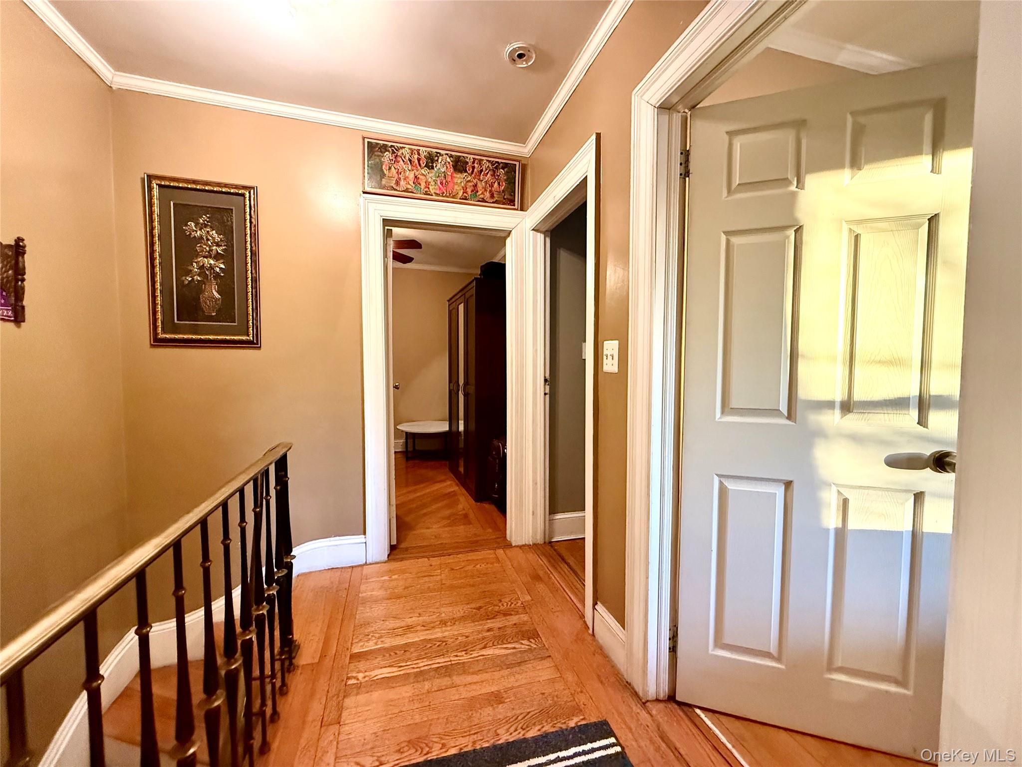 54-05 68th Street Queens, NY 11378 - Photo 22 of 47 Hallway with ornamental molding, light wood-type flooring, and an upstairs landing