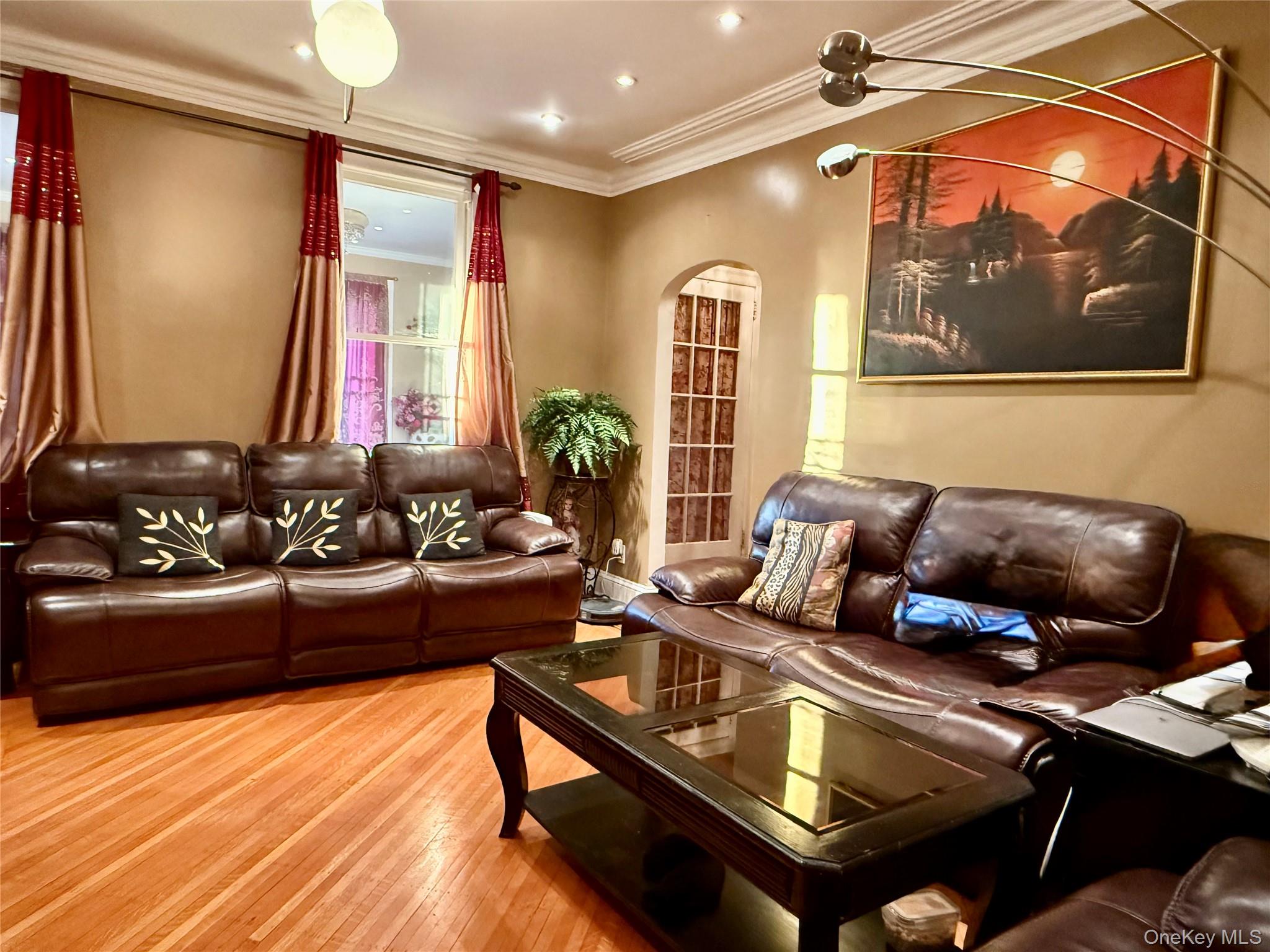 54-05 68th Street Queens, NY 11378 - Photo 6 of 47 Living room featuring arched walkways, hardwood / wood-style floors, and ornamental molding