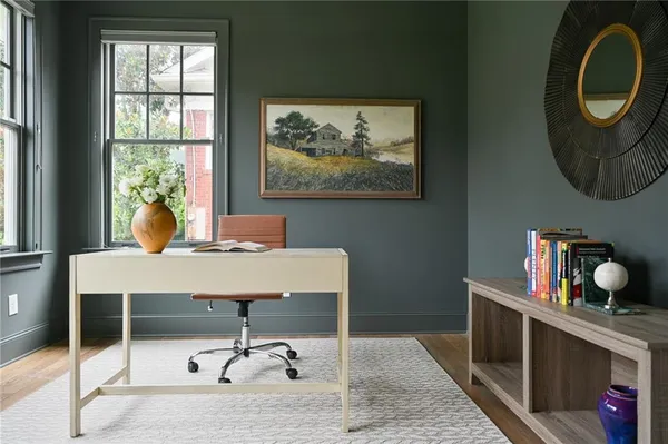 a view of a workspace with furniture and a window