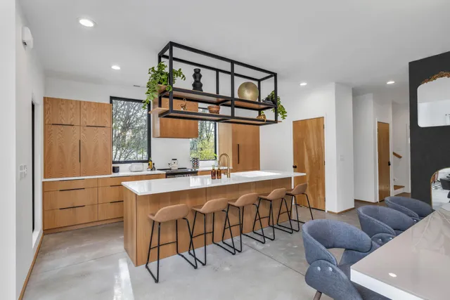 a living room with stainless steel appliances kitchen island granite countertop furniture and a refrigerator