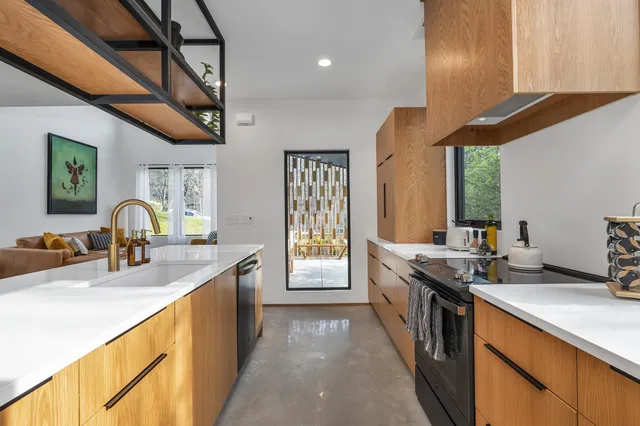a kitchen with stainless steel appliances granite countertop a sink a stove and a wooden floors