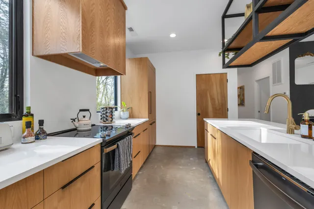 a kitchen with stainless steel appliances granite countertop a sink and a refrigerator