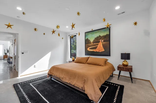 a bedroom with a bed and a painting on the wall