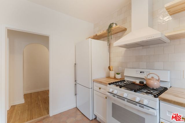 a kitchen with stainless steel appliances a refrigerator and a stove top oven