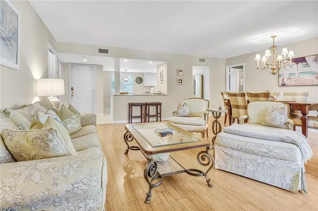 a living room with furniture and a dining table with kitchen view