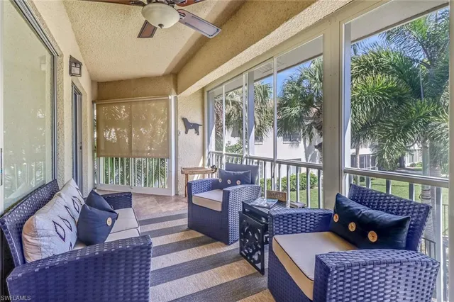 a living room with furniture and a floor to ceiling window