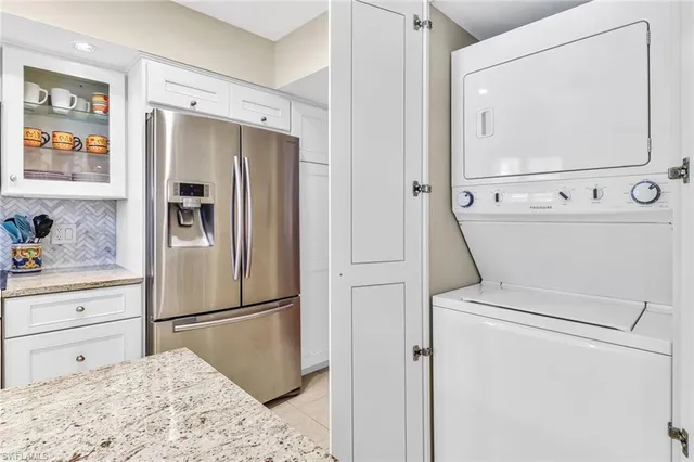 a kitchen with a refrigerator sink and cabinets