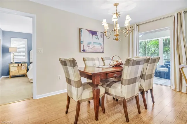 a dining room with furniture a chandelier and wooden floor