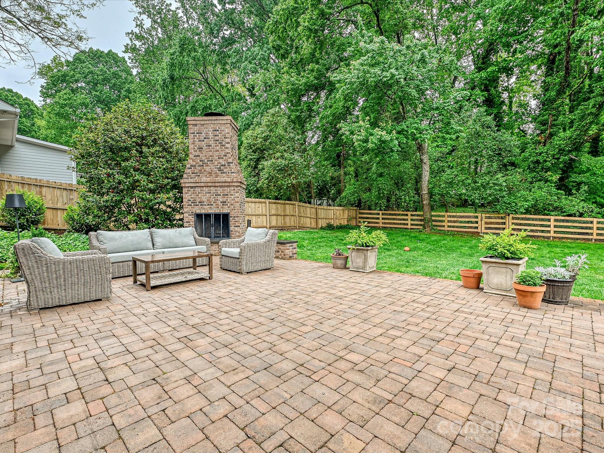 3610 Mill Pond Road Charlotte, NC 28226 - Photo 30 of 35 a view of a patio with table and chairs potted plants and a large tree