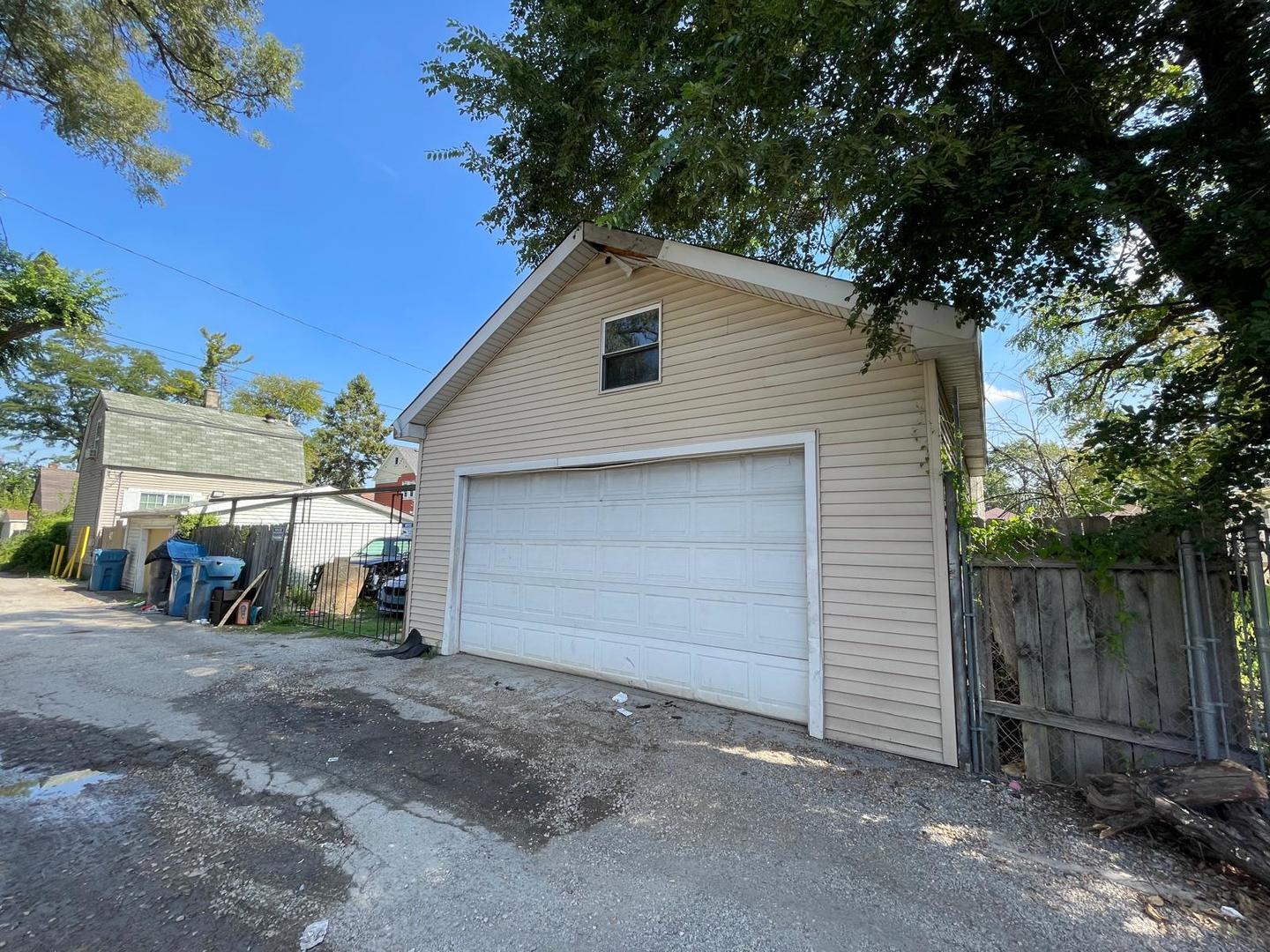 15736 Lathrop Avenue Harvey, IL 60426 - Photo 12 of 20 a view of a small house with large tree and wooden fence