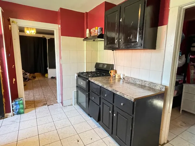 a kitchen with granite countertop a stove a sink and a microwave