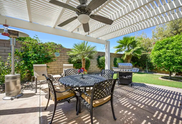 a view of a dining room and livingroom with furniture wooden floor a chandelier