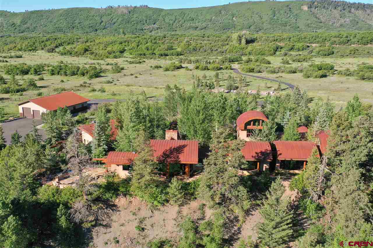 an aerial view of a house with a yard and lake view