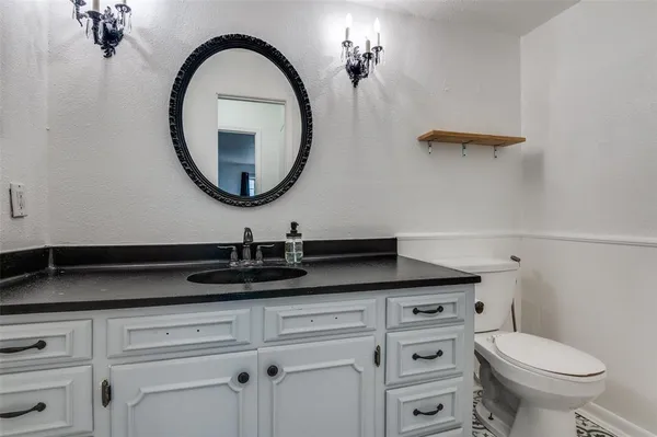 a bathroom with a granite countertop sink a toilet and bathtub