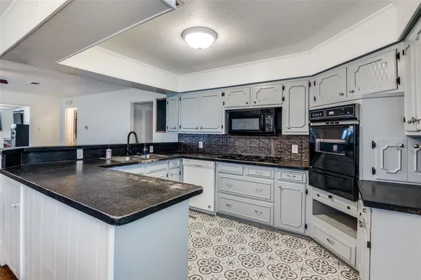 a kitchen with stainless steel appliances granite countertop a sink stove and cabinets