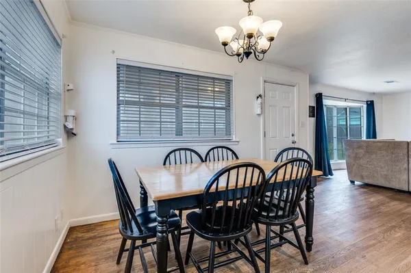a view of a dining room with furniture a chandelier and wooden floor