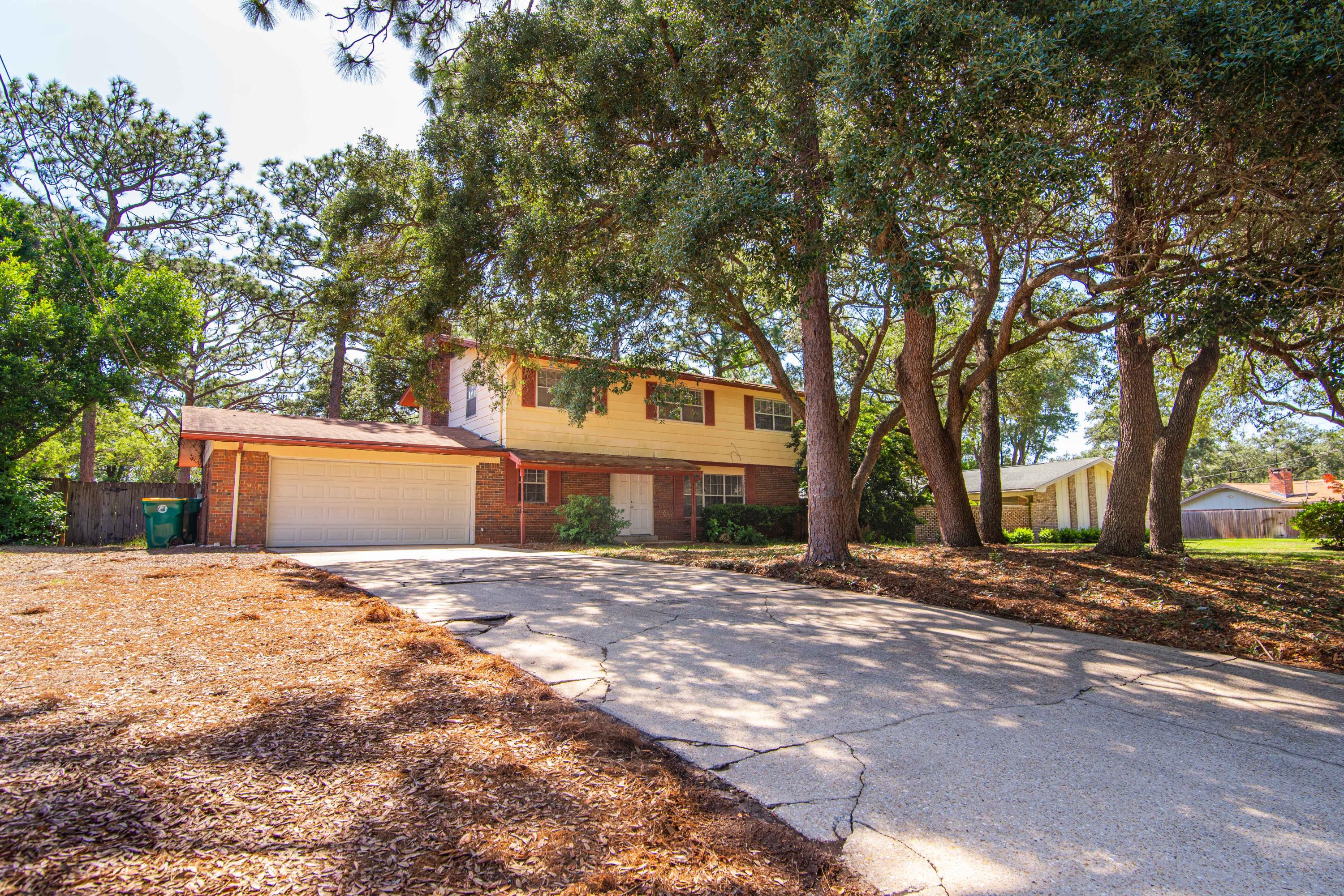 187 Country Club Road Shalimar, FL 32579 - Photo 1 of 68 a front view of a house with a yard and trees
