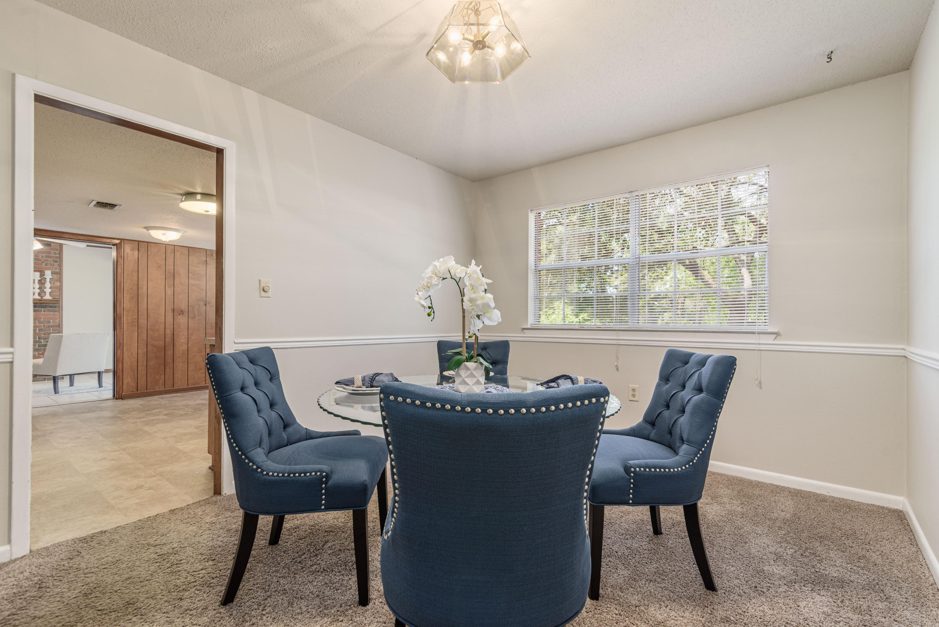 187 Country Club Road Shalimar, FL 32579 - Photo 13 of 68 a dining room with furniture a potted plant and a chandelier