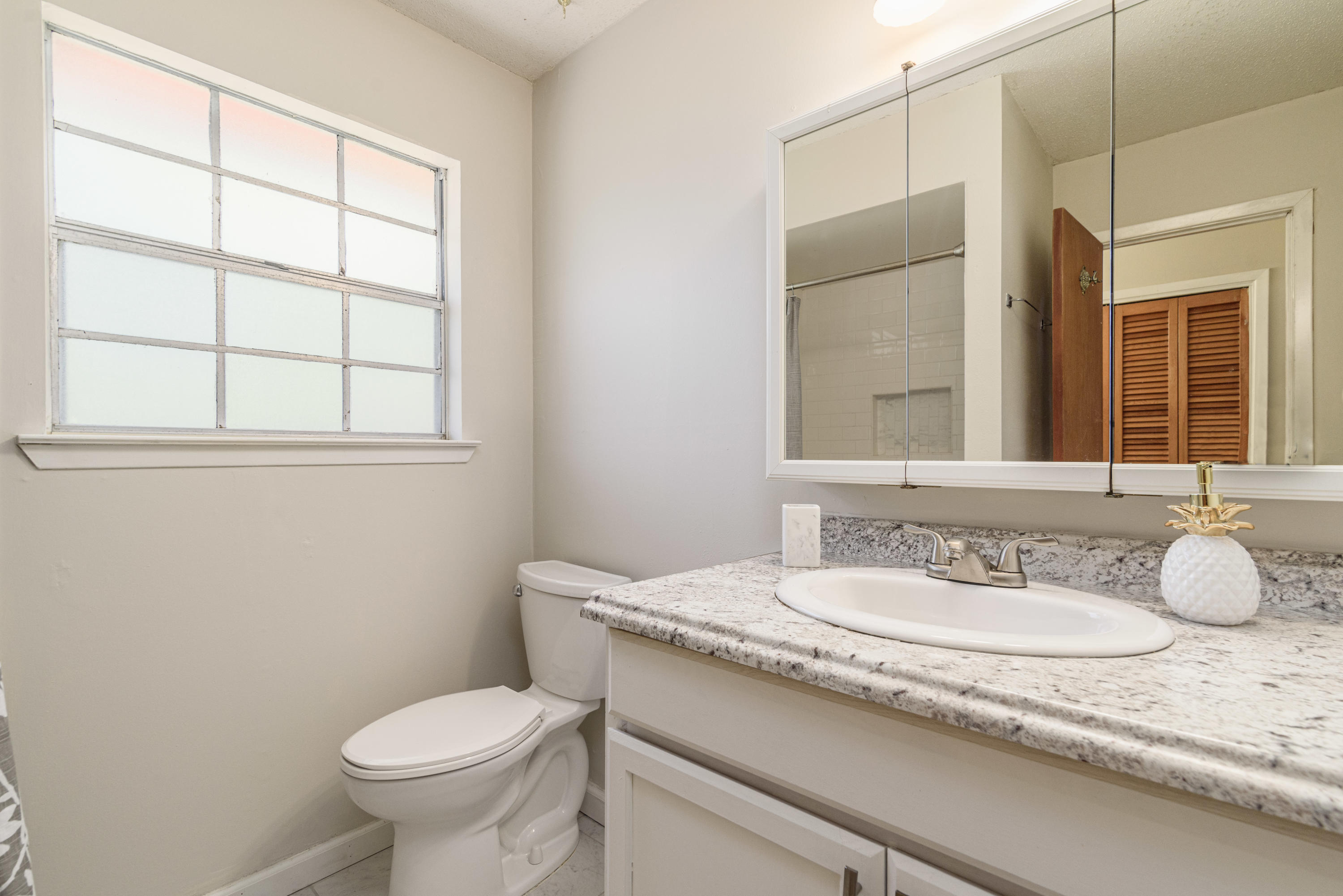 187 Country Club Road Shalimar, FL 32579 - Photo 36 of 68 a bathroom with a granite countertop sink toilet and mirror
