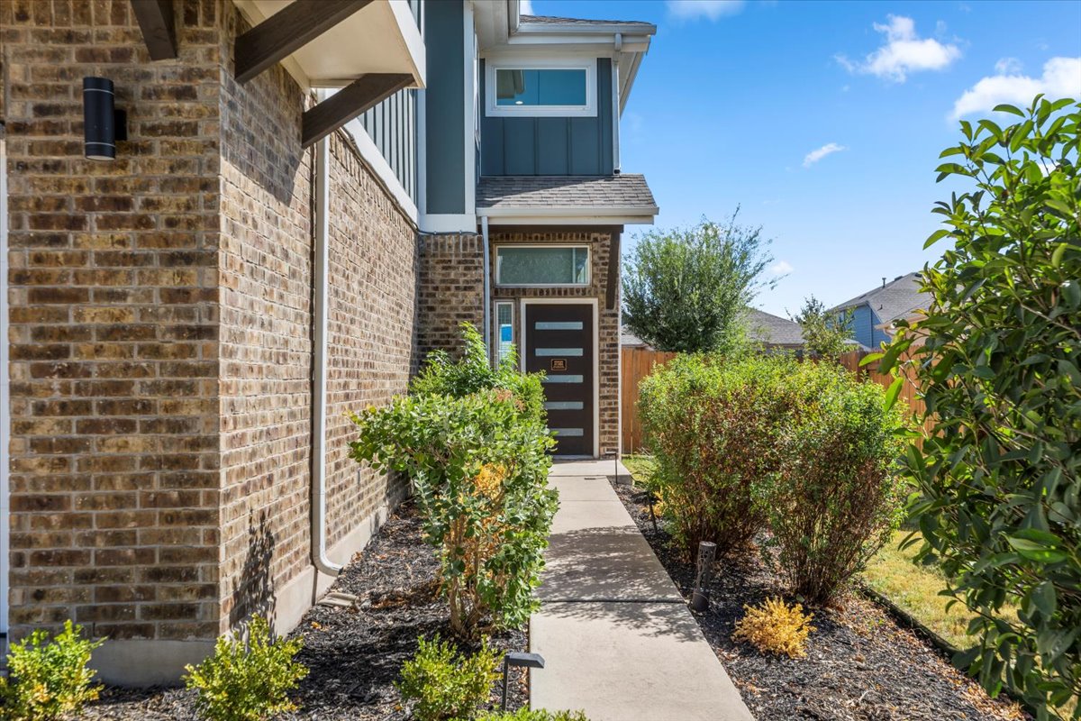 6912 Cardinal Bloom Loop Austin, TX 78744 - Photo 4 of 33 A welcoming walkway leads to this charming brick and siding residence with thoughtful landscaping.