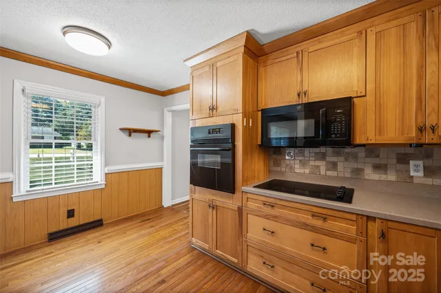 a kitchen with stainless steel appliances wooden cabinets a stove and a microwave