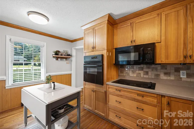 a kitchen with stainless steel appliances wooden cabinets a stove and a microwave