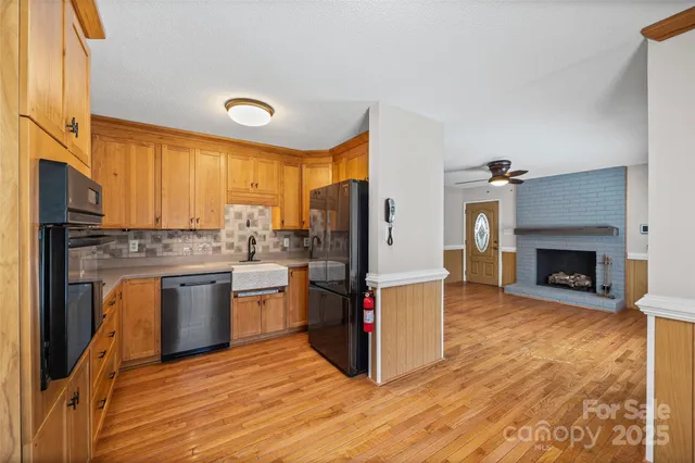 a kitchen with stainless steel appliances granite countertop a refrigerator a stove and a wooden floors