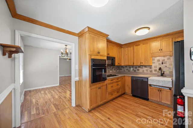 a view of an empty room with wooden floor fireplace and a window