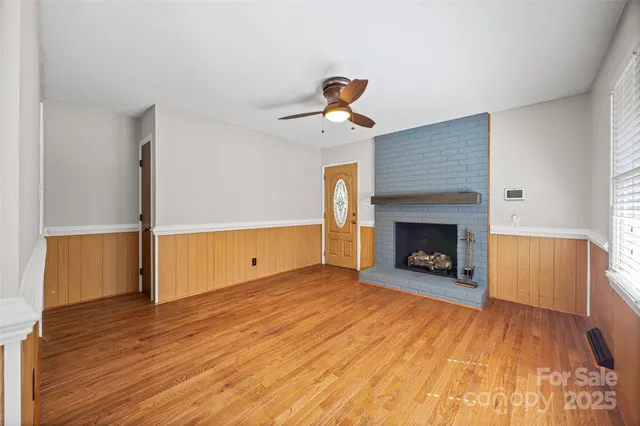 a view of a livingroom with a fireplace and a ceiling fan