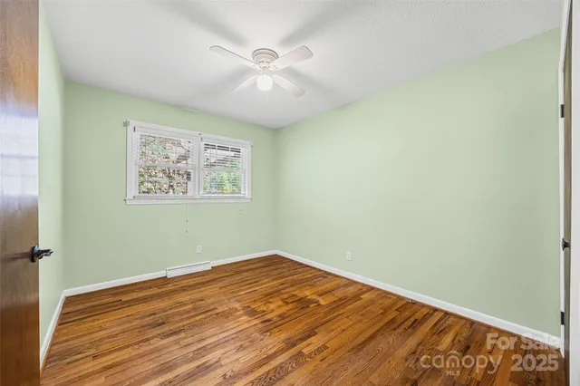 an empty room with a window and wooden floor