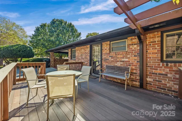 a view of a patio with table and chairs a barbeque with wooden floor and fence