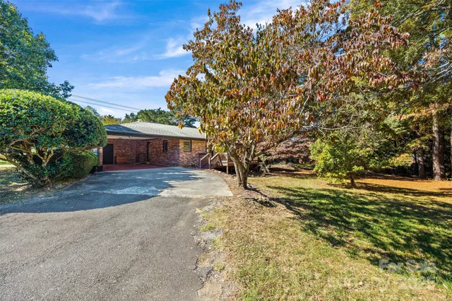 a front view of a house with a yard and trees