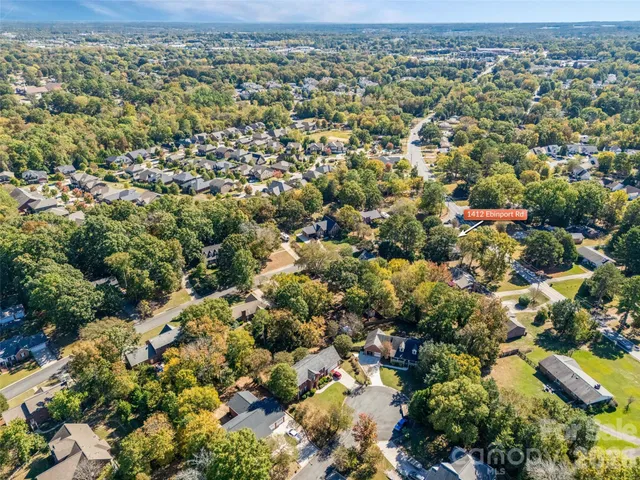 an aerial view of residential houses with outdoor space and trees